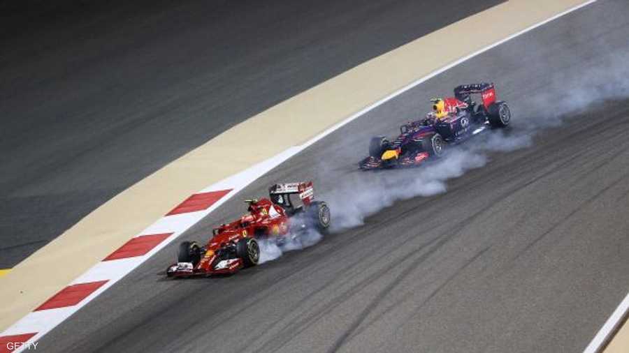 الدخات يتصاعد من سيارة فيراري التي يقودها الفنلندي كيمي رايكونين أمام الأسترالي دانيال ريكاردو سائق سيارة ريد بول