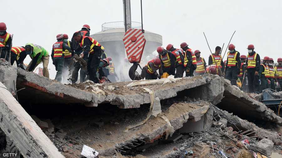 عمال الإنقاذ يحاولون إزالة الركام بآلات بسيطة.