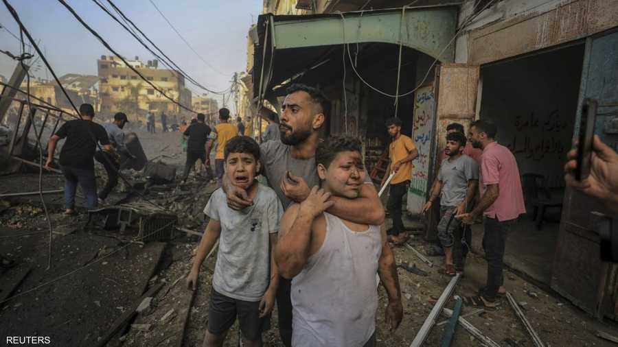 فلسطيني يحتضن ابني شقيقه بعد قصف إسرائيلي